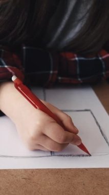 Dikey video. Sanat terapisi. Çizen kız. Resim stüdyosu. Kadın çocuk kağıdın üzerinde oturuyor, oturma odasının içinde..