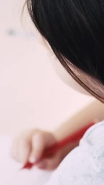 Dikey video. Çocuklar resim yapıyor. Sanatsal süreç. En sevdiğim hobi. Beyaz kağıda hayvan ve ağaç çizen tanınmamış bir kız..