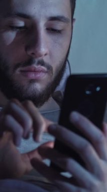 Dikey video. Gece sohbeti. Gadget uykusuzluğu. Çevrimiçi iletişim. Akşamları akıllı telefondan mesaj atan bıkkın bir adam..