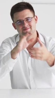 Dikey video. Bravo alkış. Destekleyici adam. Sanal toplantı. Akıllı adam masa başında oturmuş el çırpıyor. Işık odasındaki meslektaşlarını teşvik ediyor..