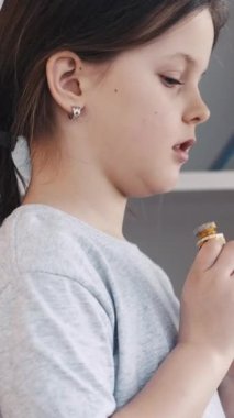 Dikey video. Sanatsal aletler. Güzel kız. Boya hazırlığı. Küçük bir kız çocuğu stüdyo içinde renkli boya tüpleri seçiyor..