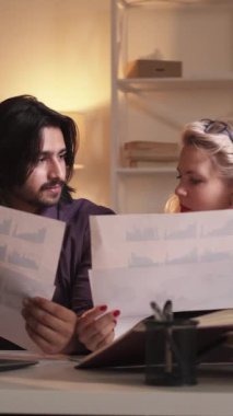 Dikey video. İş brifingi. İstatistik incelemesi. Şirket toplantısı. Grafikler üzerinde verileri tartışan çeşitli meslektaşlar.