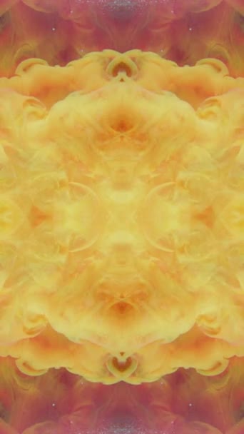 垂直ビデオ ペイントスプラッシュ 万華鏡のデザイン インクの水 黄色オレンジ煙雲爆発対称的なパターン抽象的な背景 — ストック動画