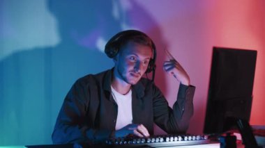 Akışı izliyorum. Çevrimiçi toplantı. Gece işi. Sıkıcı erkek bilgisayar monitörüne bakıyor. Pürüzsüz döngü jesti düşünüyor. Video oyunları oynuyor..