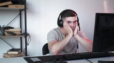 Serbest bir iş. Siber uzay oyuncusuyum. Kulaklıklı rahat bir adam online turnuva başlatmak için bekliyor. Gözleri evde oturan kusursuz bir döngü..