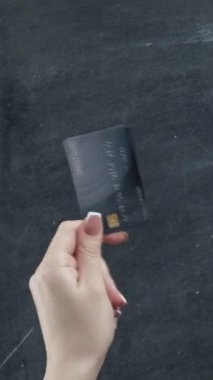 Dikey video. Para jestleri. Nakit para transferi. Kredi kartı hayranı bir kadın el ele tutuşuyor..