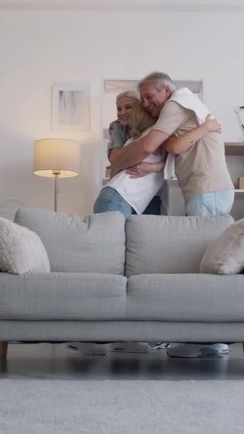 垂直录像 家庭会议 女学生 享受这一刻 快乐的父母拥抱着女儿 坐在家里明亮的沙发上 — 图库视频影像