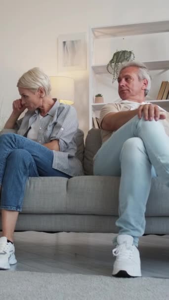 垂直ビデオ 家族の意見の相違 夫婦の喧嘩だ 怒っている中年の男と女座ってソファターンバックお互いにでライトホームインテリア — ストック動画