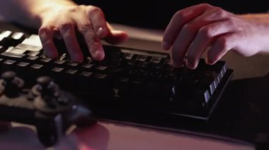 Sanal rekabet. Gece eğlencesi. Çevrimiçi iletişim. Adam elleri klavye yazarken video oyunu turnuvası koyu renk ışık.