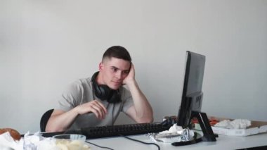 Sıkıcı oyun. Klavye yazıyorum. Yorgun adam oyuncu düğmeye basıyor. Tuşsuz düğmeye basıyor. Yorgun adam evde oyun oynuyor..