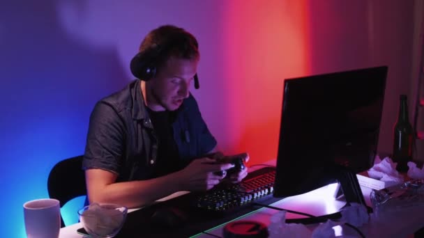 サイバー ウィニング オンライン競争 エンターテイメントドライブ 暗い光の家のインテリアで喜びの感情陶酔を使用してコンピュータを再生する幸せな表情の男性 — ストック動画