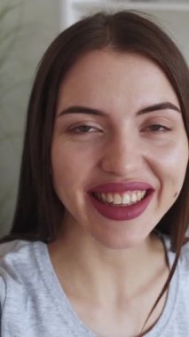 Dikey video. Akıcı kadın. Nüfuz blogu. Çevrimiçi iletişim. Müritlerle konuşan mutlu kız ışık odasının içinde içerik yaratıyor..