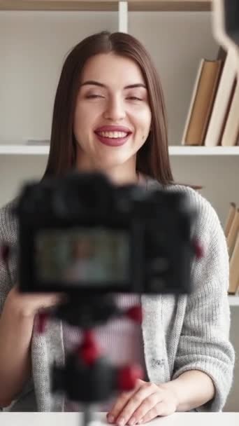 垂直ビデオ 女ブロガー コンテンツの記録 明るい部屋のインテリアで加入者と通信する写真カメラで撮影された幸せなインスピレーションを受けた女性 — ストック動画