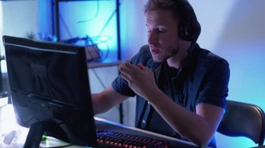 Oyun akışı. Siber rekabet. Kulaklık takan, internetten pizza yiyen, evde oturup bira içen bir adam..