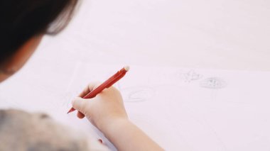 Yaratıcı bir resim. Çocuklar resim yapıyor. Sanat hobisi. Kalem masası bulanık beyaz kağıda resim çizen tanınmamış bir çocuk..