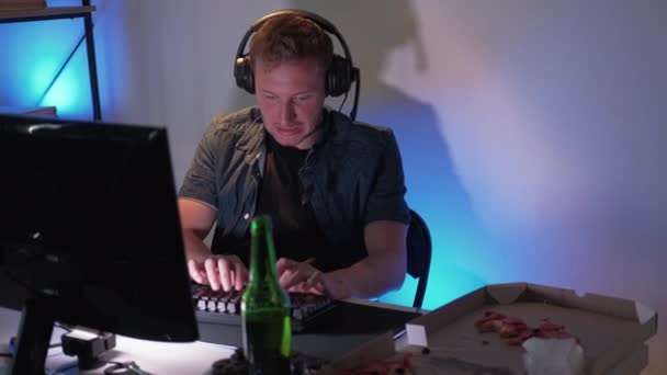 网络游戏游戏 在线比赛 穿着耳机在电脑上玩键盘和队友坐在霓虹灯下聊天的退出的家伙 — 图库视频影像