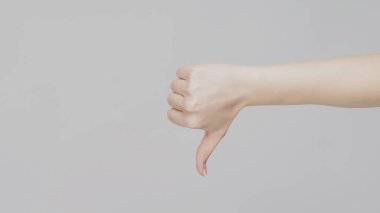 Jestlerden hoşlanmaz. Kötü bir fikir. Açık gri fotokopi arkaplanında baş parmağını gösteren kadın el.