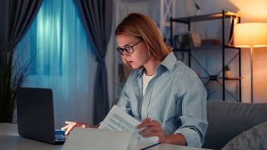 Geç saatlere kadar çalışıyorum. Meşgul kadın. Çevrimiçi araştırma. Yoğunlaşmış kadın bilgisayarla çok çalışıyor. Karanlık odada oturup notlar alıyor..