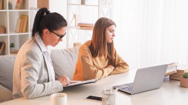 Özel ders veriyorum. Ev ödevi. Öğretmen yardımı. Genç kız dizüstü bilgisayarında öğretmeniyle ders çalışıyor ve kitap koçluğu yapıyor..