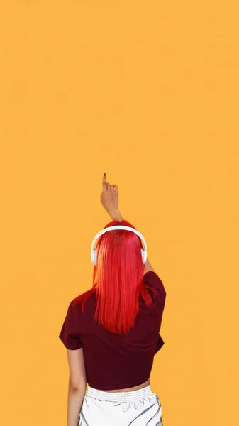 애플리케이션 헤드폰 현대적 헤드폰을 착용하고 확신에 소녀가 오렌지색빈 공간에서 보이지 — 스톡 사진