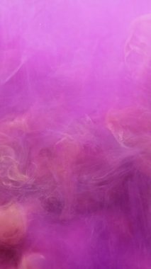 Dikey video. Renkli duman dokusu. Suyu boya. Sihir. Neon pembe pigment duman bulutu akışı soyut sanat arkaplanı.