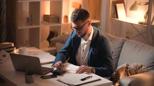 会計処理だ 男性専門家 財務計算 暗室内の文書と計算機座って机を使用してスマート濃縮男 — ストック写真