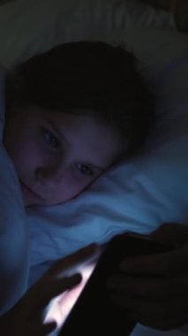 Dikey video. Çocuk bağımlılığı. Cihaz gecesi. Uykusuz kız sörf yaparken sıkılıyor. İçeriği izliyor. Akşamları akıllı telefondan sosyal medyada geziniyor..