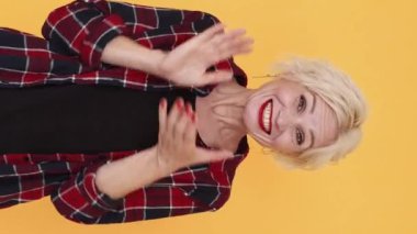 Dikey video. Bravo alkış. Suratsız kadın. İyi iş çıkardın. Şüpheci orta yaşlı kadın el çırpıyor aptalca sevinç pozları veriyor..