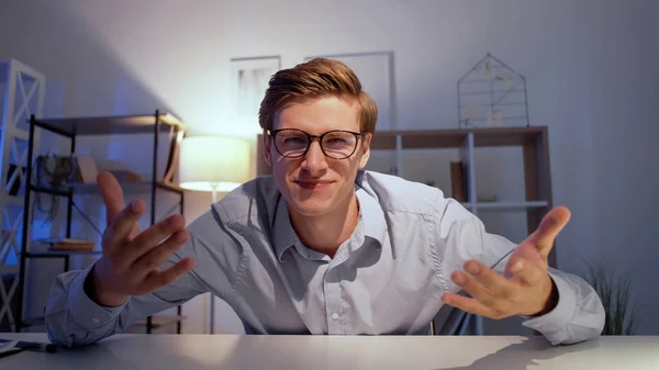 オンライン会議 刺激を受けた男 ビデオレビュー スマートな幸せな男座って机感情的にジェスチャーでライトホームルームインテリア — ストック写真