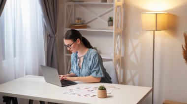 İnternet işi. İstatistik analizi. Bağımsız yaşam tarzı. Modern iş yerlerinde dizüstü bilgisayar grafikleri kullanarak ev ofisinden çalışan yoğun kadın çalışanlar..