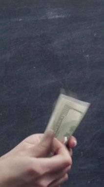 Dikey video. Aile parası. Para paylaşımı. Karı koca, paralarını sayarak 4 adet el hareketini gösteriyor..