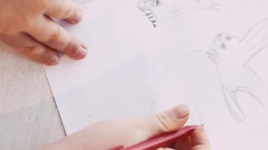 Yaratıcı bir resim. Çocuklar resim yapıyor. Sanat hobisi. Beyaz kağıda kalem oturma masası çizen tanınmamış bir çocuk..