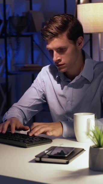 영상입니다 온라인 디지털 남자가 어두운 실내의 사무실에서 컴퓨터 키보드를 있습니다 — 비디오