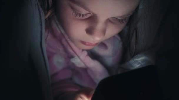 睡前电话睡不着的孩子 晚上在线 好奇的小女孩在夜深人静的时候用毛毯下的小玩意上网 — 图库视频影像