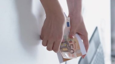 Dikey video. İş ahlaksızlığı. Yasadışı anlaşma. Gizli ödeme. Tanınmayan kadın para sayıyor Euro banknotları rüşvet parası hazırlıyor.