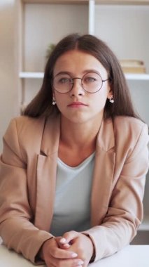 Dikey video. İnternet araması. Sıkıcı bir konuşma. Takım elbiseli, gözlüklü, ilgisiz iş kadını hafif ofiste başını sallayıp etrafa bakıyor..