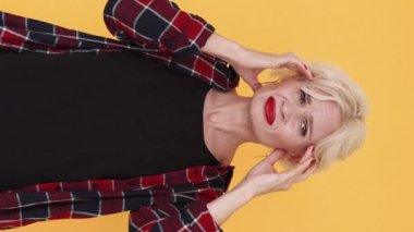 Dikey video. Baş ağrısı bunalımı. Acı çeken kadın. Kötü duygular. Bunalımlı orta yaşlı kadın el ele tutuşuyor şakaklara masaj yapıyor..