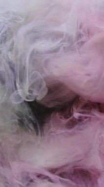 Dikey video. Mürekkep damlası. Buhar dokusu. Açığa çıkarma etkisi. Pembe beyaz duman bulutu siyah simli toz parçacıkları üzerinde hareket sıçratır soyut sanat arkaplanı.