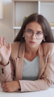 Dikey video. Çevrimiçi çağrı. Hoşnutsuz patron. İş iletişimi. Sabırsız, takım elbiseli iş kadını beyaz ofisteki internet konferansında iç çekişini dinliyor..