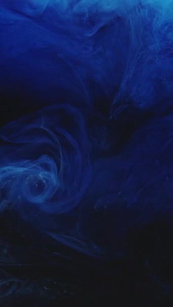 垂直ビデオ インクの水が落ちる 色の煙スプラッシュ 明らかに効果がある 濃い黒の抽象アートの背景に青いフューム雲爆発波の動き — ストック動画