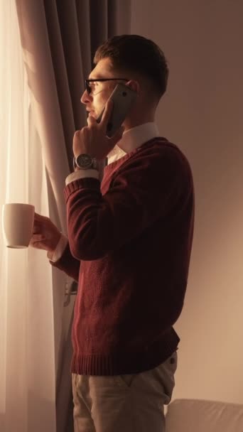 垂直录像 重要的电话优雅的男人 移动通信 聪明而随和的人 会讲智能手机 喝咖啡 看窗户 — 图库视频影像