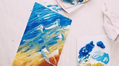 Sanat stüdyosu. Kadın ressam. Yaratıcı süreç. Tanımlanamayan bir kadın spatulayla resim yapıyor ve tuvalde soyut bir resim oluşturuyor..