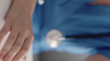 Dikey video. Doktor ücreti. Sağlık sigortası ödemesi. Tanımlanamayan kadın doktorların eli hastadan para alıyor. 100 Amerikan doları nakit para sayıyor..