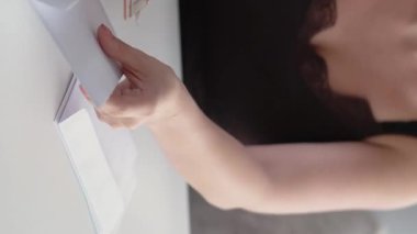 Dikey video. Tasarruf. Bütçe hesabı. Finansal zenginlik. Tanımlanamayan kadın zarftan nakit para sayıyor..