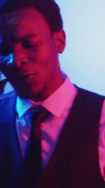 Dikey video. Mobil çatışma. Rahatsız edici bir arama. İletişim sorunu. Kırmızı mavi ışık kızgın iş adamını telefonda tartışırken rahatsız etti..