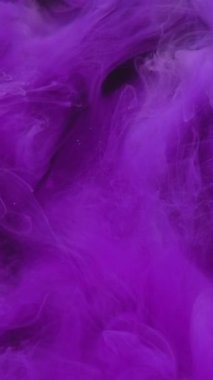 Dikey video. Mürekkep damlası. Renkli duman sıçraması. Açığa çıkarma etkisi. Fantezi bulanıklığı. Siyah soyut sanat arka planında neon mor duman bulutu patlama dalgası hareketi.