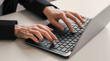 Bilgisayar işi. İş aleti. Dijital pazarlama. Çevrimiçi iş teknolojisi. Beyaz ofis masasında dizüstü bilgisayarda yazı yazan kadın elleri..