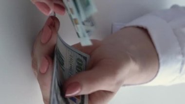 Dikey video. Tasarruf. Kâr geliri. Maaş ödemesi. Zengin iş kadınlarının eli 100 Amerikan doları nakit sayıyor..