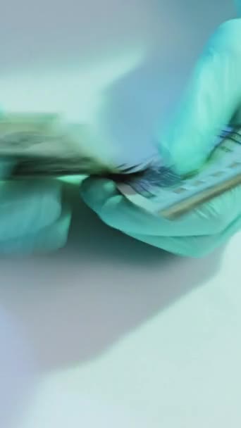垂直录像 博士腐败 医疗费用 医护人员手戴防护手套 数着钞票 钞票堆在白桌子上 — 图库视频影像
