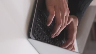 Dikey video. İnternet işi. Dijital pazarlama. İnternet araştırması. Bilgi teknolojisi. İş yerinde dizüstü bilgisayarda yazan erkek işçilere yakın çekim.